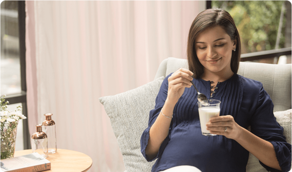 Pregnant woman enjoying a glass of milk as part of her pregnancy diet