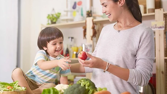Mummy sharing apple with kid to ensure his health for grow