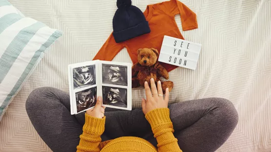 Pregnant mother holding ultrasound scans 