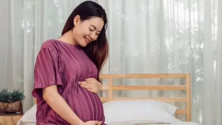 portrait-young-adult-asian-pregnant-woman-touching-her-belly-with-love-home Large.