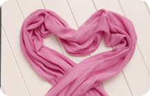 Pink shawl for pregnant ladies laid down in a heart-shaped form