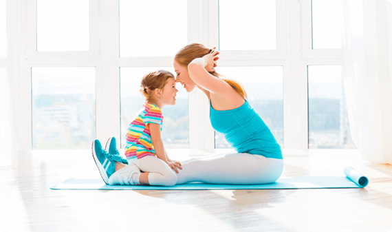 Mother plays and interacts with her child while doing yoga work out 