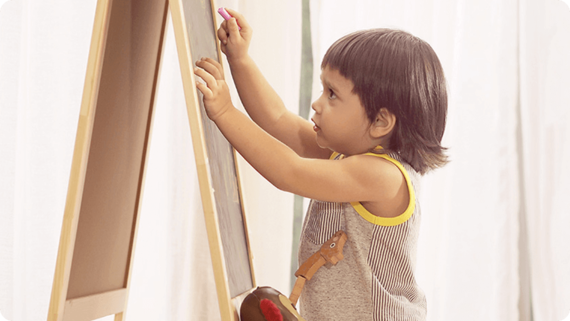 Toddler writing on chalkboard