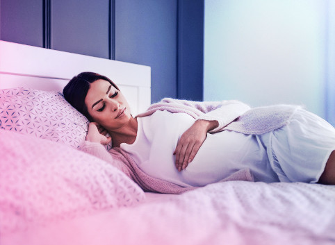 Pregnant woman in a comfortable sleeping position, deep in slumber, experiencing vivid dreams