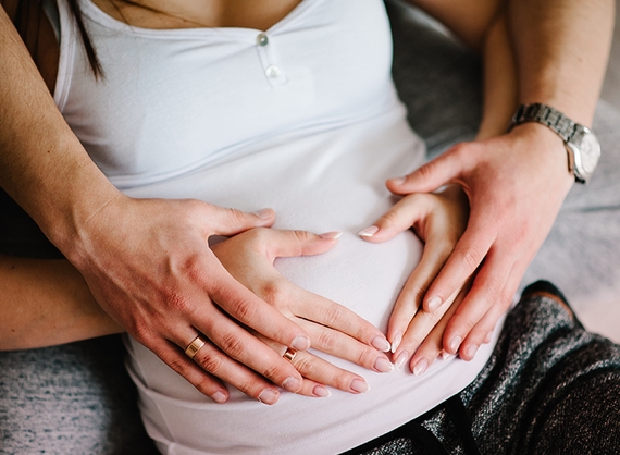 Parents put hands on pregnant belly