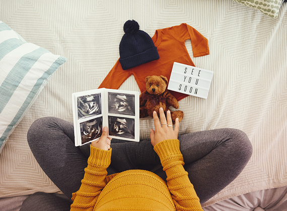 Pregnant mother holding ultrasound scans 
