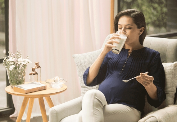 Pregnant mom drinking maternal milk after stir well