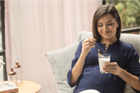 Pregnant woman enjoying a glass of milk as part of her pregnancy diet