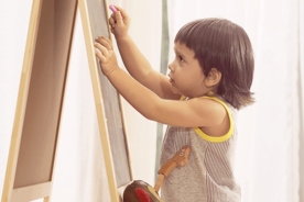 Toddler writing on chalkboard