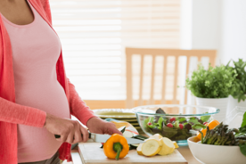 Pregnant woman preparing nutrition-based meal