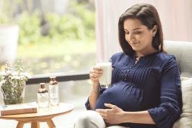 A mother holding a cup of pregnancy milk