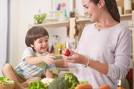 Mummy sharing apple with kid to ensure his health for grow