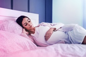 Pregnant woman in a comfortable sleeping position, deep in slumber, experiencing vivid dreams