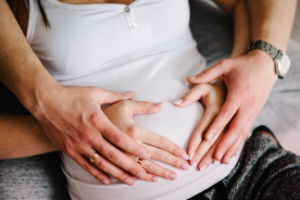 Parents put hands on pregnant belly