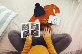 Pregnant mother holding ultrasound scans 