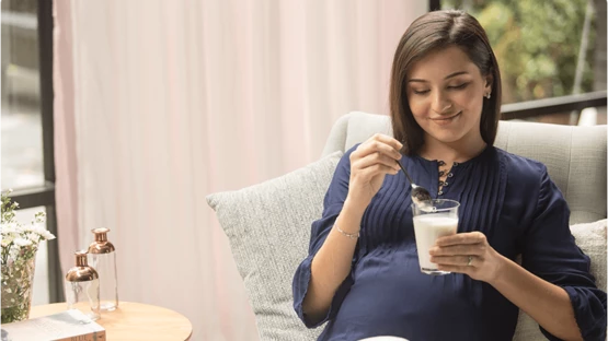 Pregnant woman enjoying a glass of milk as part of her pregnancy diet