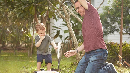Family activity of a father and his son catching a fish 