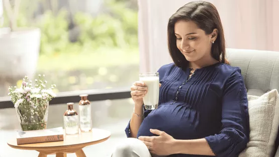 A mother holding a cup of pregnancy milk