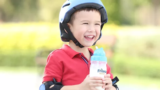 Red shirt kid holding Friso Gold formula milk