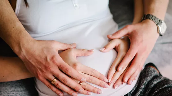 Parents put hands on pregnant belly