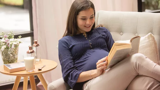 A pregnant woman reading a book