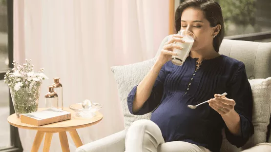 Pregnant mom drinking maternal milk after stir well