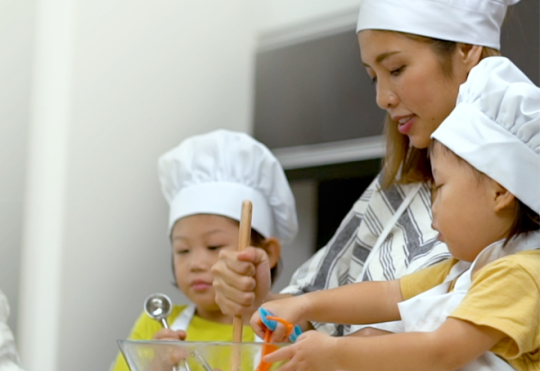 A mother baking with 2 children