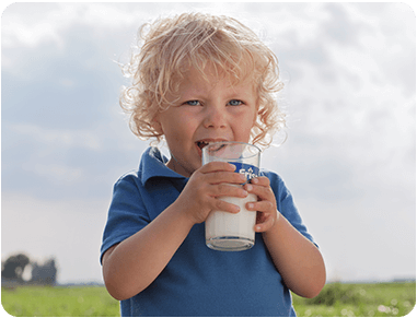 Child holding a cup of Friso® Gold milk