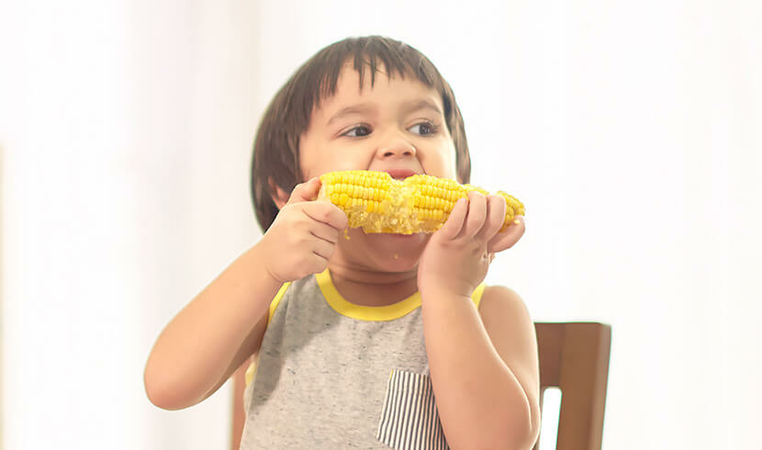 Kid having corn to ensure sufficient of nutrient